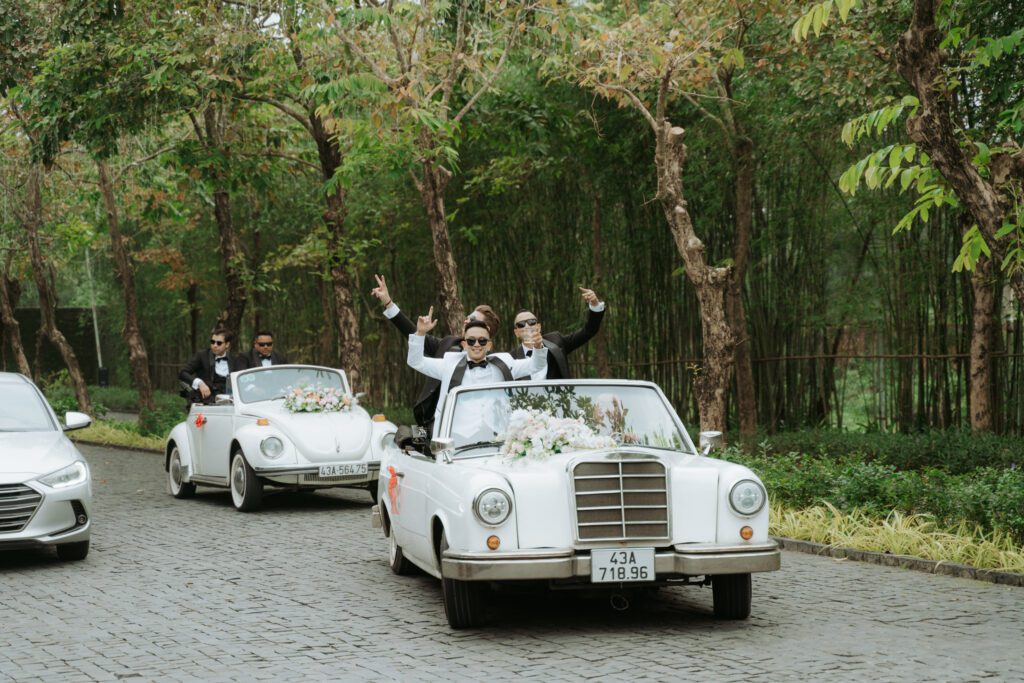 The groom and his friends arrive in vintage cars surrounded by greenery, capturing the ease of moving between Da Nang’s city conveniences and resort wedding venues.
